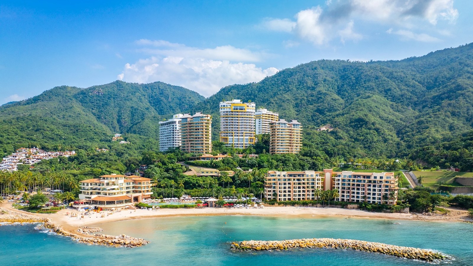 Garza Blanca and Hotel Mousai resort towers above the Puerto Vallarta coastline with beach and mountain views